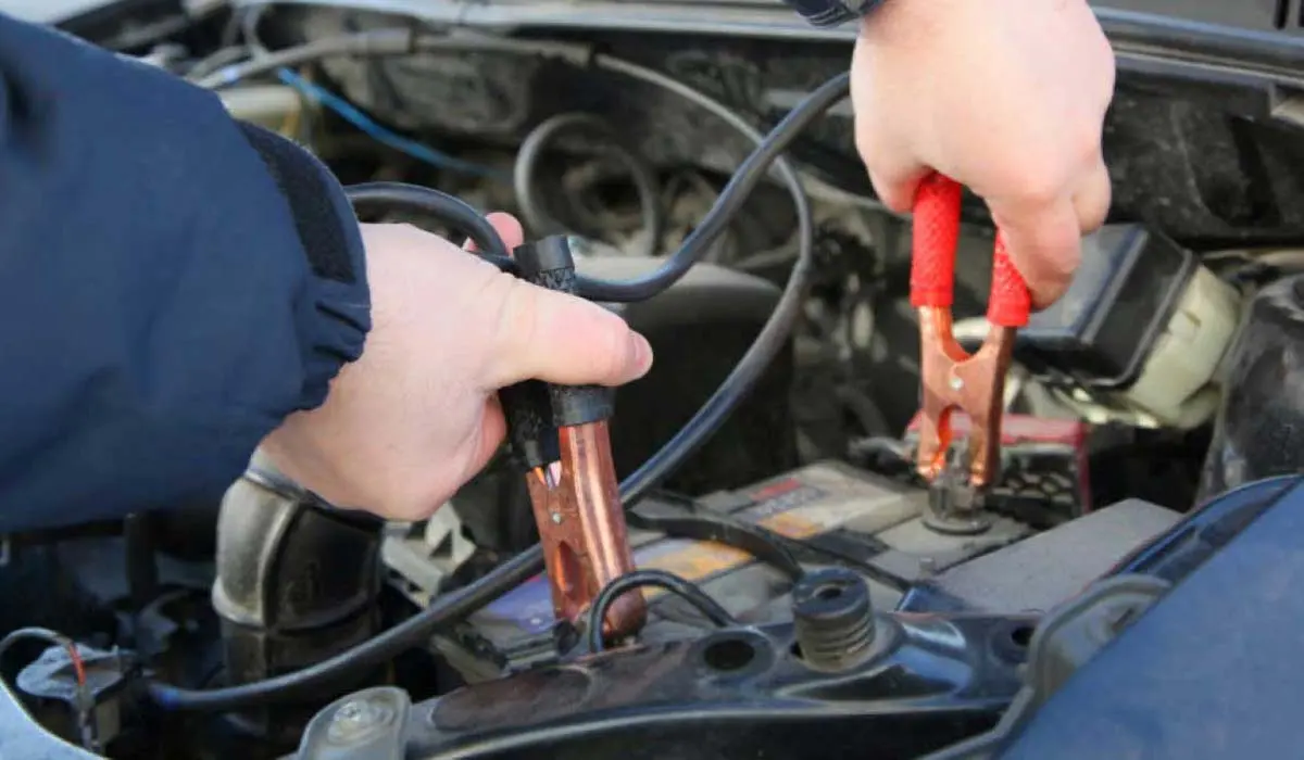 Técnico conectando los cables a la batería de un carro